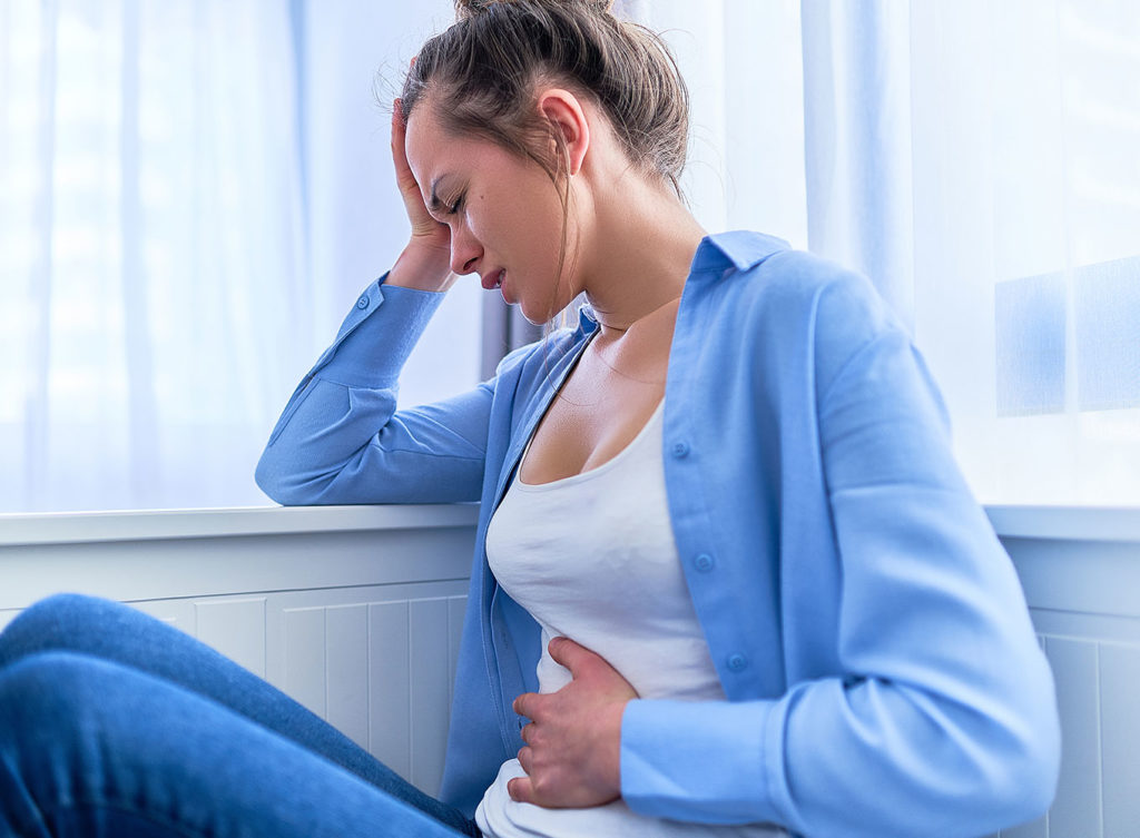 woman with nausea holding her stomach