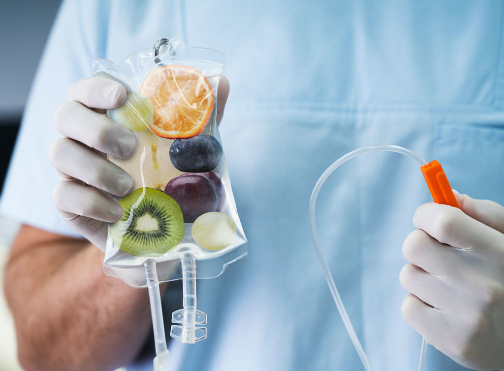 doctor holding up an iv bag with fruit inside it to indicate iv infusion therapy dallas texas