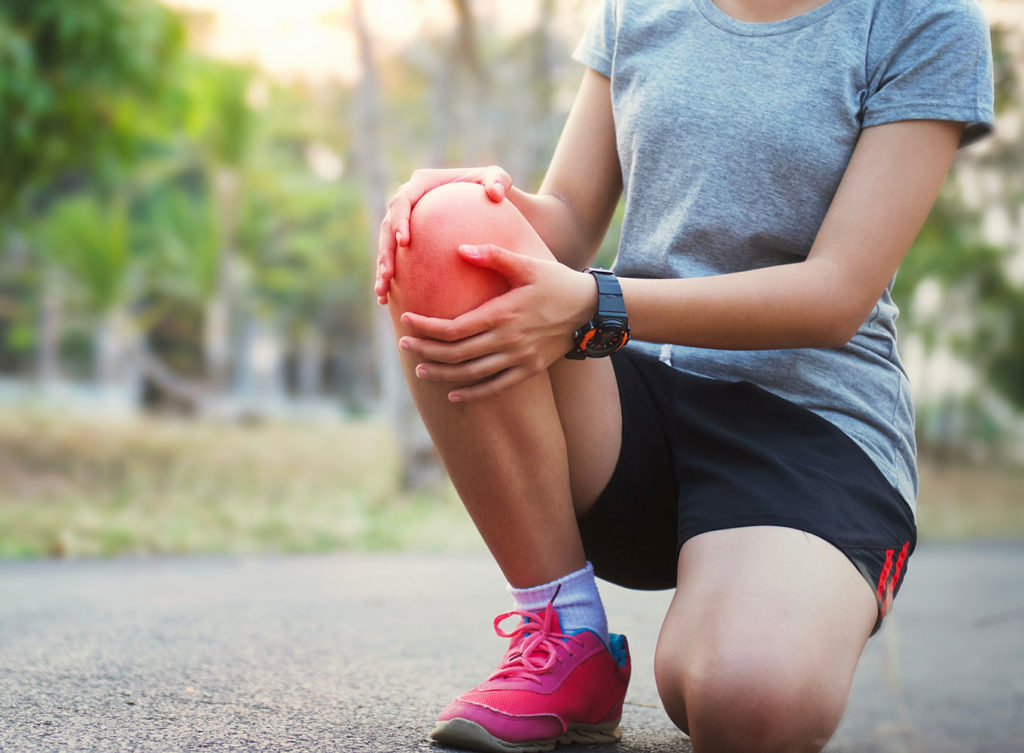 female runner holding her knee in pain dallas tx