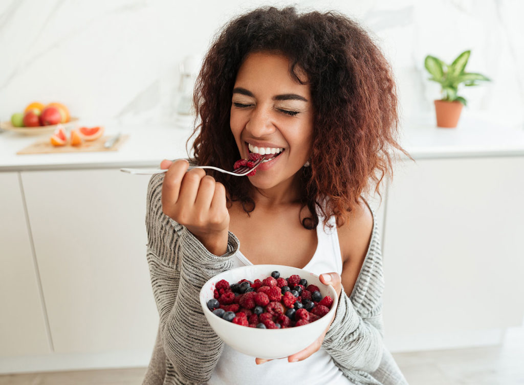 young woman enjoying a bowl of fruits working on her weight loss approach with phentermine dallas tx