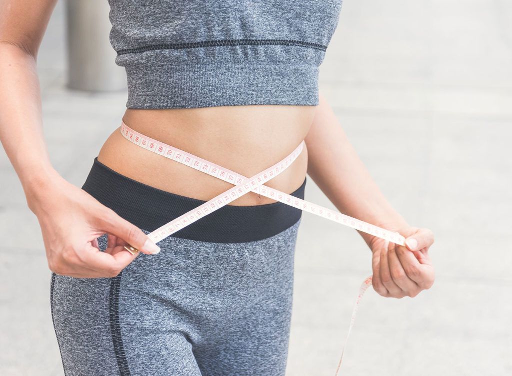 woman measuring her waist after having a semiglutide weight loss treatment mckenney tx