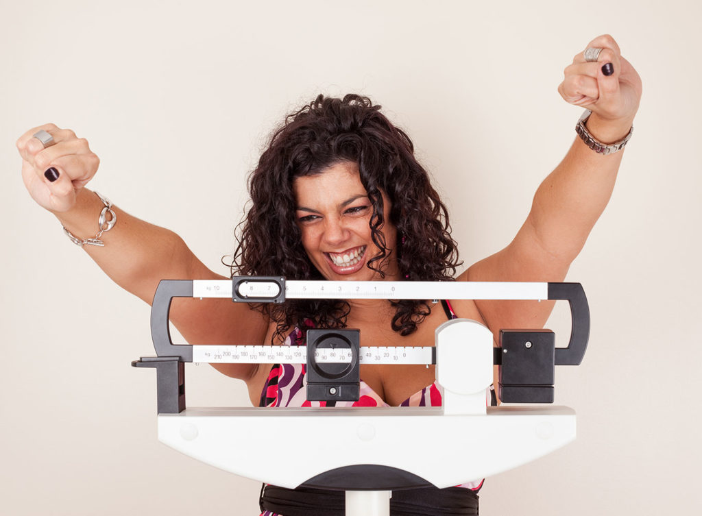 woman standing on a scale who had a successful weight loss treatment plano tx