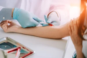Close-up hands of a nurse administering routine blood tests and extracting blood samples from a patient in a hospital in Farmer's Branch, TX.