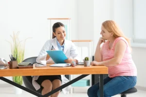 A young female doctor consulting with a patient in an office in Farmer's Branch, TX to customize a personal weight loss plan.