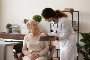 Simply Direct Medicine—A female doctor explains menopause to an older female patient in her medical office in Farmers Branch, TX.