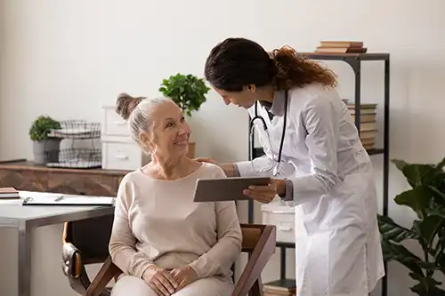 Simply Direct Medicine—A female doctor explains menopause to an older female patient in her medical office in Farmers Branch, TX.
