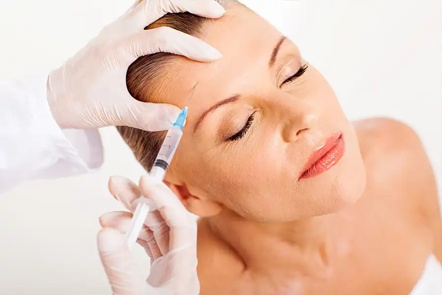 Simply Direct Medicine—A doctor injects a female patient in the forehead with PRP in an office in Farmers Branch, TX.