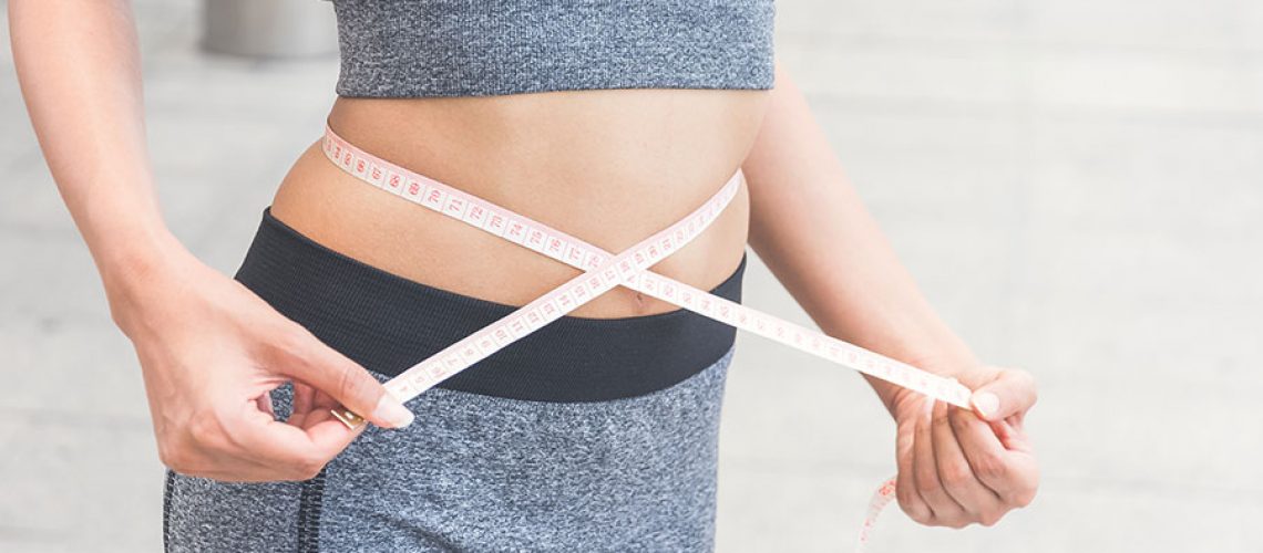 A person holding a measuring tape around their waist to measure weight loss that has been effective with semaglutide from Simply Direct Medicine in Dallas, TX.